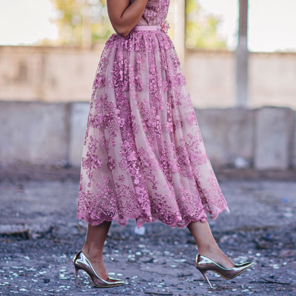 Person wearing a pink floral dress and high heels in an outdoor setting